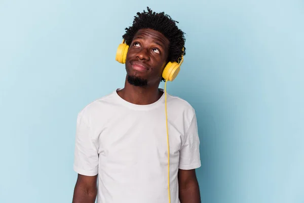 Young African American Man Listening Music Isolated Blue Background Dreaming — ストック写真