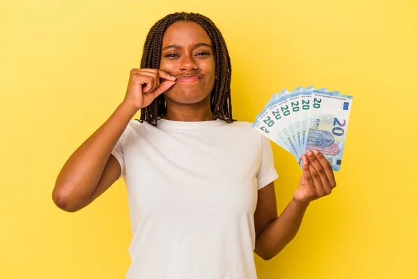 Mladá Africká Američanka Drží Bankovky Izolované Žlutém Pozadí Prsty Rtech — Stock fotografie