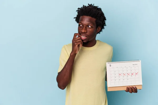 Jonge Afro Amerikaanse Man Houdt Kalender Geïsoleerd Blauwe Achtergrond Ontspannen — Stockfoto