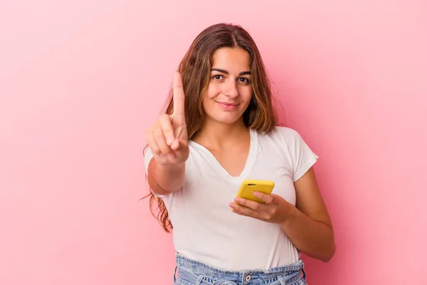 年轻的高加索女人用粉色背景的手机隔离 显示第一手指 — 图库照片