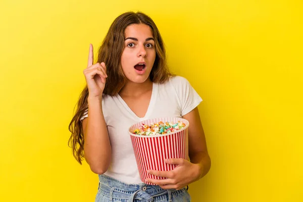 Jovem Caucasiana Segurando Uma Pipoca Isolada Fundo Amarelo Tendo Uma — Fotografia de Stock