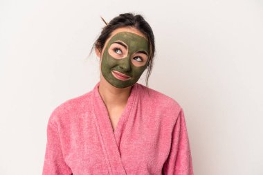 Young caucasian woman wearing a facial mask isolated on white background dreaming of achieving goals and purposes