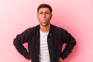 Sarı arka planda izole edilmiş beyaz dövmeli genç bir adam. Komik ve dost canlısı bir dil uzatıyor..