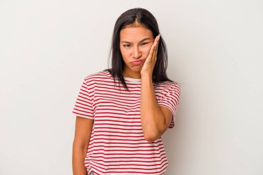 Beyaz arka planda izole edilmiş, üzgün ve dalgın hisseden genç Latin kadın fotokopi odasına bakıyor..