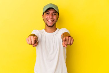 Sarı arka planda izole edilmiş dövmeli beyaz bir adam. Önü işaret eden neşeli gülümsemeler..