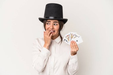 Young magician woman holding a wand isolated on white background biting fingernails, nervous and very anxious.