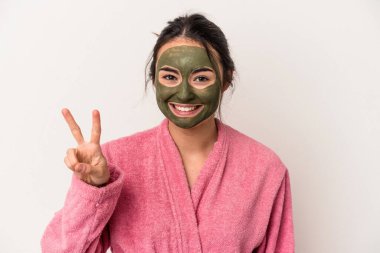 Young caucasian woman wearing a facial mask isolated on white background showing number two with fingers.