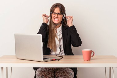 Beyaz arka planda izole bir şekilde seyahat eden beyaz saçlı genç bir kadın elleriyle kulaklarını kapatıyor..