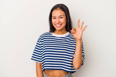 Beyaz arka planda izole edilmiş genç Latin bir kadın neşeli ve kendinden emin..