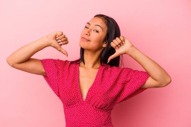 Pembe arka planda izole edilmiş genç Latin kadın gururlu ve kendinden emin hissediyor, örnek olarak..