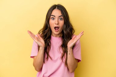 Sarı arka planda izole edilmiş genç beyaz kadın şaşırdı ve şok oldu..