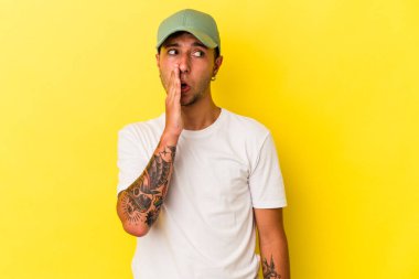 Sarı arka planda izole edilmiş dövmeleri olan beyaz genç bir adam gizli bir fren haberinin olduğunu söylüyor.