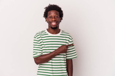 Beyaz arka planda izole edilmiş genç Afrikalı Amerikalı adam gülümsüyor ve boş alanda bir şeyler gösteriyor..