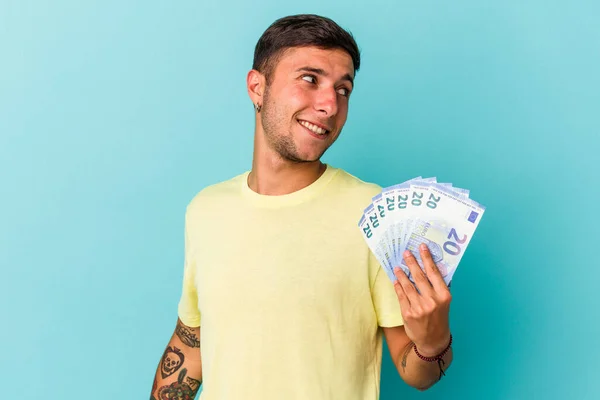 Joven Hombre Caucásico Sosteniendo Billetes Aislados Sobre Fondo Azul Mira — Foto de Stock