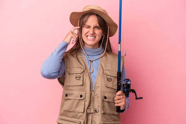 Young Caucasian Fisherwoman Holding Rod Isolated Pink Background Covering Ears — 图库照片