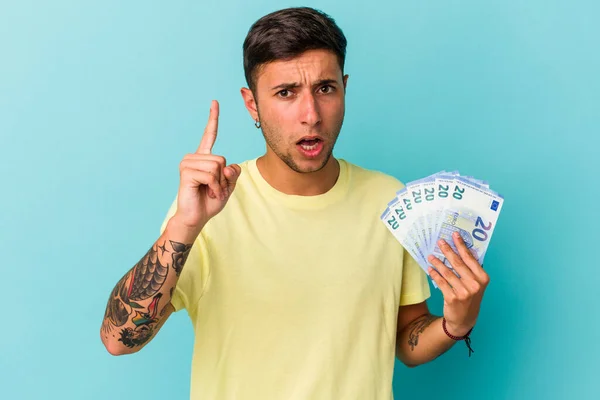 Joven Hombre Caucásico Sosteniendo Billetes Aislados Sobre Fondo Azul Teniendo — Foto de Stock