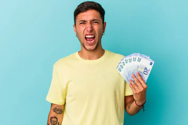 Joven Hombre Caucásico Sosteniendo Billetes Aislados Sobre Fondo Azul Gritando — Foto de Stock