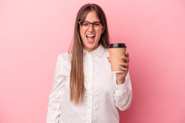 Kafkasyalı genç bir kadın pembe arka planda izole edilmiş bir şekilde çok sinirli ve agresif çığlıklar atıyor..