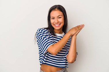 Beyaz arka planda izole edilmiş genç Latin kadın enerjik ve rahat hissediyor, ellerini ovuşturuyor..