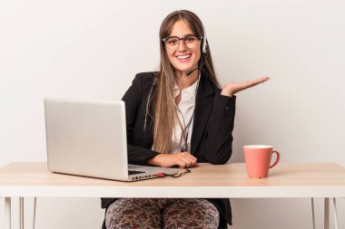 Beyaz arka planda seyahatler yapan beyaz tenli genç bir kadın bir avuç içinin fotokopi çektiğini ve başka bir elini belinde tuttuğunu gösteriyor..