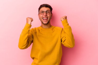 Sarı arka planda izole edilmiş dövmeleri olan, tasasız ve heyecanlı genç beyaz bir adam. Zafer konsepti.