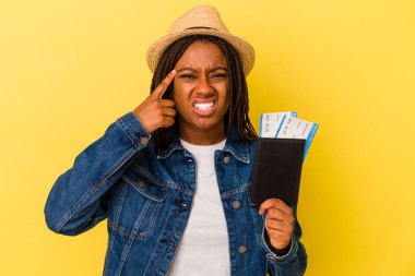 Sarı arka planda pasaportu olan Afro-Amerikalı genç bir kadın işaret parmağıyla hayal kırıklığı gösteriyor..