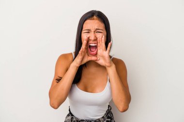 Beyaz arka planda izole edilmiş genç Latin bir kadın heyecanlı bir şekilde bağırıyor..