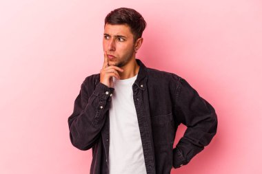 Sarı arka planda izole edilmiş dövmeleri olan genç beyaz bir adam ya sır saklıyor ya da sessizlik istiyor..