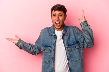 Sarı arka planda dövmeleri olan beyaz bir genç avucunun içinde fotokopi alanı tutuyor, el üstünde tutuyor. Şaşırmış ve mutlu..