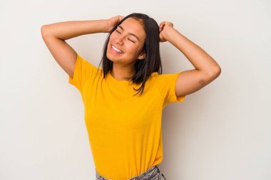 Beyaz arka planda izole edilmiş genç Latin bir kadın özel bir günü kutluyor, atlıyor ve enerjiyle kollarını kaldırıyor..