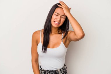 Beyaz arka planda izole edilmiş genç Latin bir kadın bir şeyi unutuyor. Alnına avuç içiyle vurup gözlerini kapatıyor..