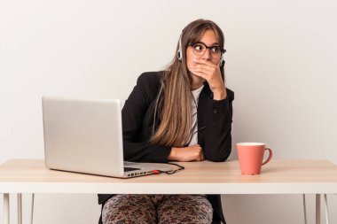 Beyaz arka planda yalnız başına seyahat eden beyaz tenli genç bir kadın. Ağzını eliyle kapatan bir fotokopi odasına özenle bakıyor..