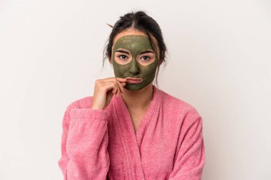 Young caucasian woman wearing a facial mask isolated on white background with fingers on lips keeping a secret.
