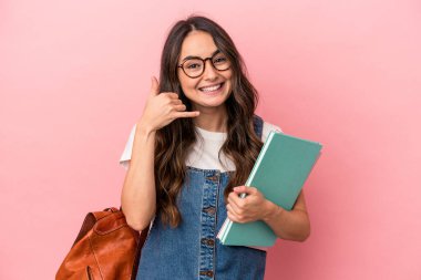 Young caucasian student woman isolated on pink background showing a mobile phone call gesture with fingers.