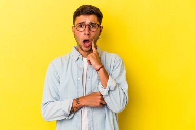 Sarı arka planda izole edilmiş dövmeleri olan beyaz bir genç adam. Harika bir fikri var, yaratıcılık kavramı..