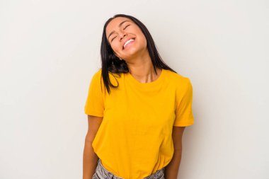 Beyaz arka planda izole edilmiş genç Latin kadın gülüyor ve gözlerini kapatıyor, rahatlamış ve mutlu hissediyor..