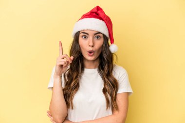 Genç beyaz kadın, sarı arka planda izole edilmiş bir şekilde Noel 'i kutluyor. Harika bir fikri var, yaratıcılık kavramı..