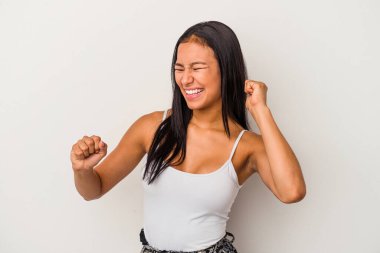 Beyaz arka planda izole edilmiş genç Latin kadın dans ediyor ve eğleniyor..