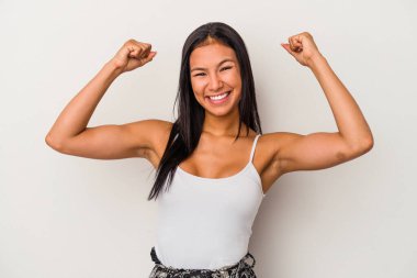 Beyaz arka planda izole edilmiş genç Latin kadın zaferden sonra yumruğunu kaldırıyor, kazanan konsept..