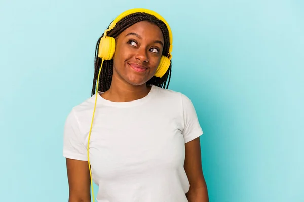 Jovem Afro Americana Ouvindo Música Isolada Fundo Azul Sonhando Alcançar — Fotografia de Stock