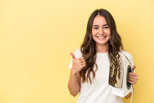 Young Caucasian Woman Holding Iron Isolated Yellow Background Smiling Raising — Foto de Stock