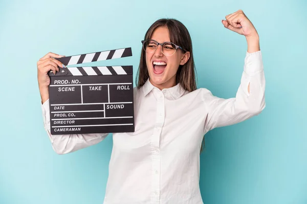 Young Caucasian Woman Holding Clapperboard Isolated Blue Background Raising Fist — Stock Photo, Image