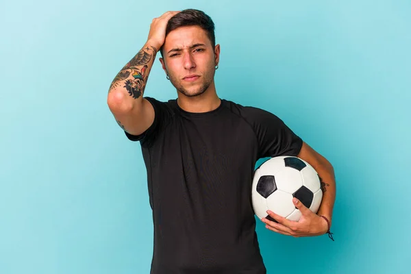 Młody Mężczyzna Gra Piłkę Nożną Trzymając Piłkę Niebieskim Tle Jest — Zdjęcie stockowe