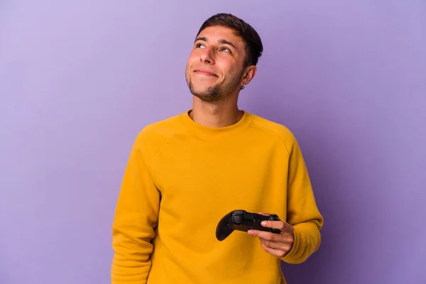 Junger Kaukasischer Mann Hält Spielcontroller Isoliert Auf Violettem Hintergrund Und — Stockfoto