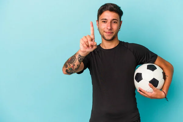 Young Man Playing Soccer Holding Ball Isolated Blue Background Showing —  Fotos de Stock