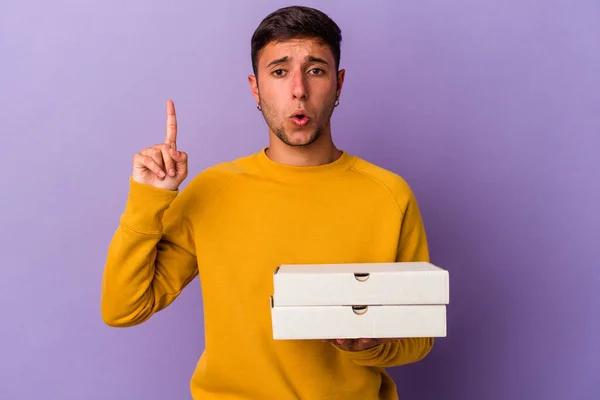 Joven Hombre Caucásico Sosteniendo Pizzas Aisladas Sobre Fondo Púrpura Teniendo — Foto de Stock