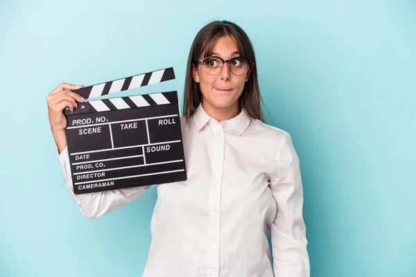 Mujer Caucásica Joven Sosteniendo Clapperboard Aislado Sobre Fondo Azul Confundido —  Fotos de Stock