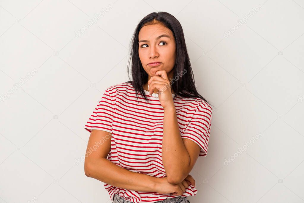 Young latin woman isolated on white background  relaxed thinking about something looking at a copy space.