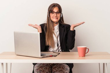 Beyaz arka planda yalnız başına seyahat eden beyaz bir kadın. Kopya alanını tutmak için kafası karışık ve omuz silkiyor..