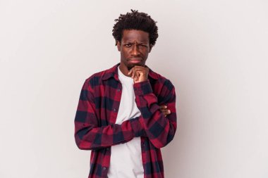 Genç Afrikalı Amerikalı bir adam beyaz arka planda izole edilmiş düşünüyor, yukarı bakıyor, yansıtıyor, düşünüyor, bir fantezi kuruyor..